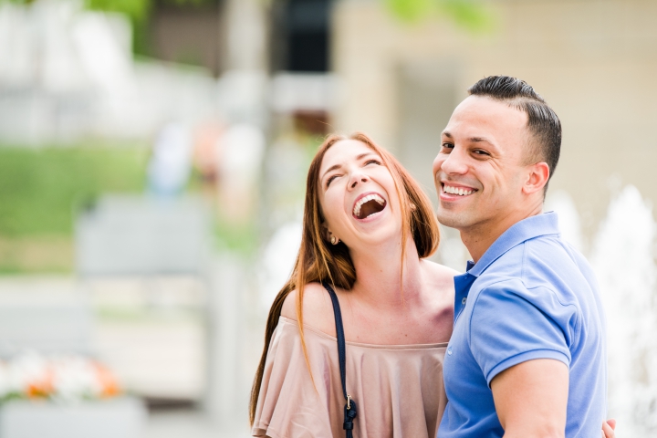young man and woman couple laughing after surprise proposal downtown cincinnati