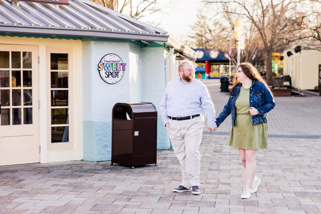 Hannah and Andrew walking next to the Sweet Spot at Kings Island Amusement Park engagement session.