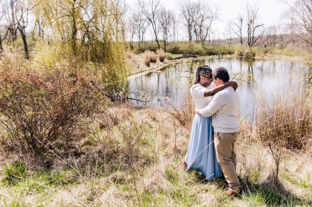 Kenny and Jonathan hugging in front of a pond