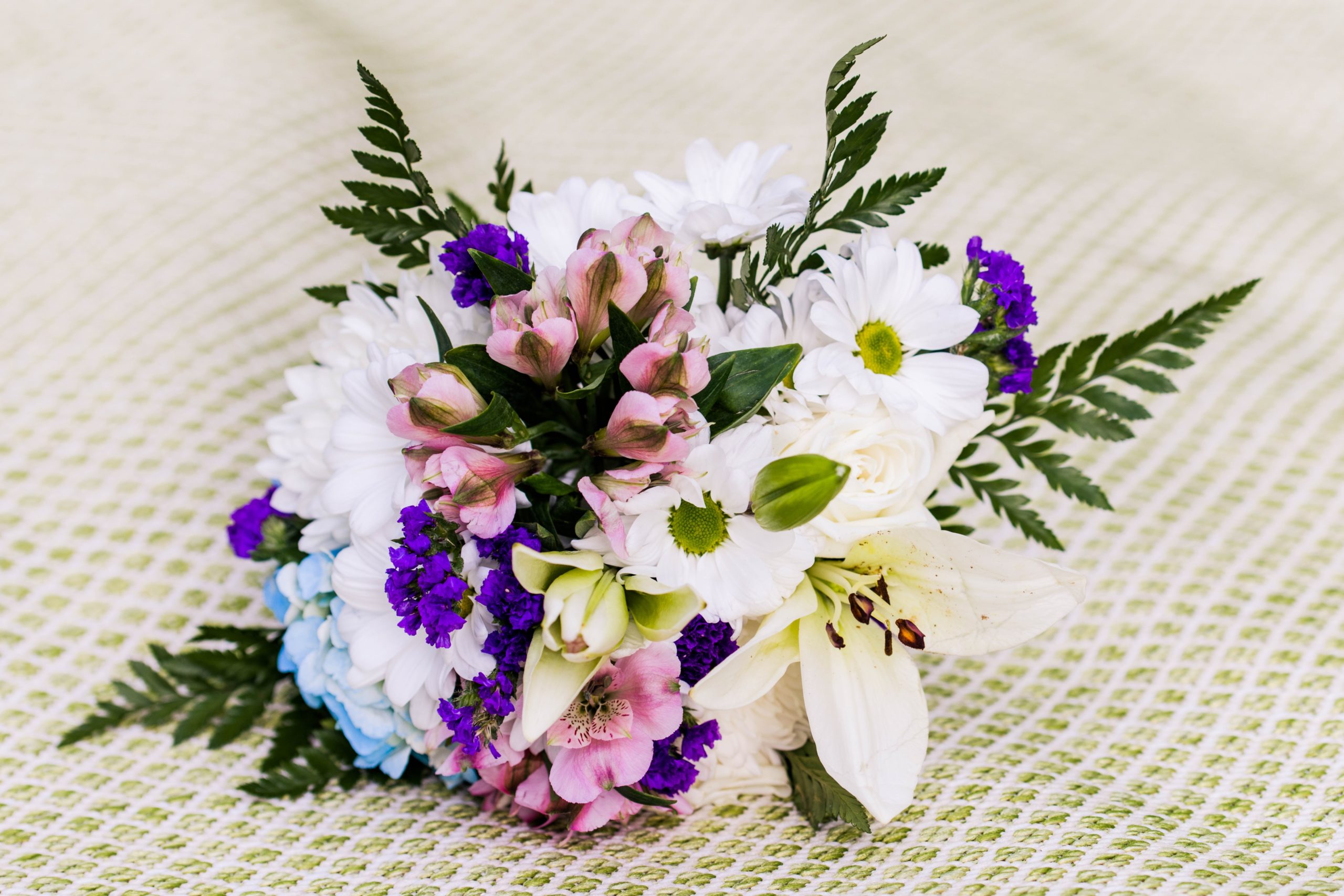 Bridal bouquet detail photos with white, blue, pink and purple flowers.