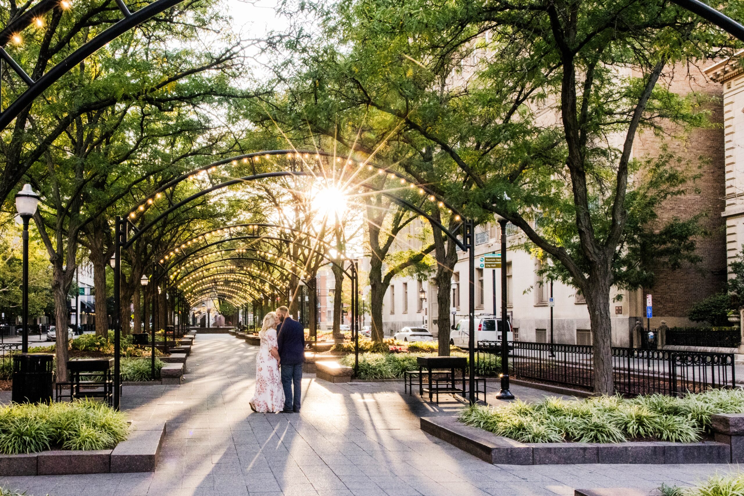 Golden hour engagement photo at Piatt Park in downtown Cincinnati of couple hugging each other from the side