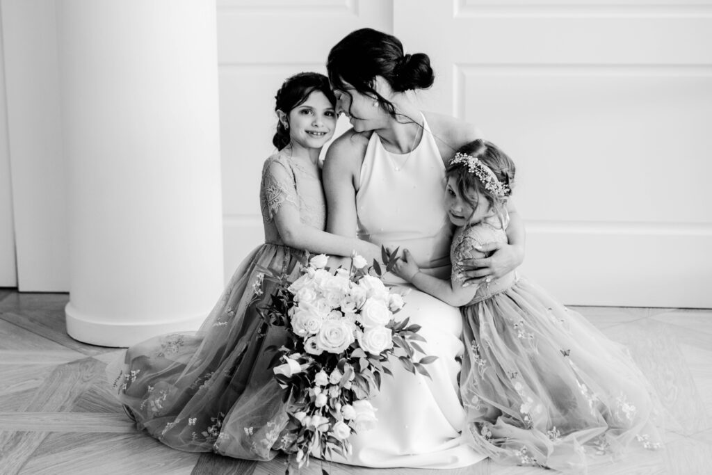 Bride sharing a candid moment with her two flower girls