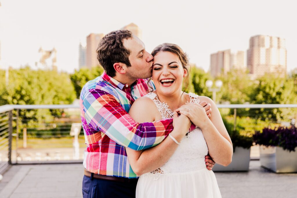 Laughing woman as fiancé kisses her