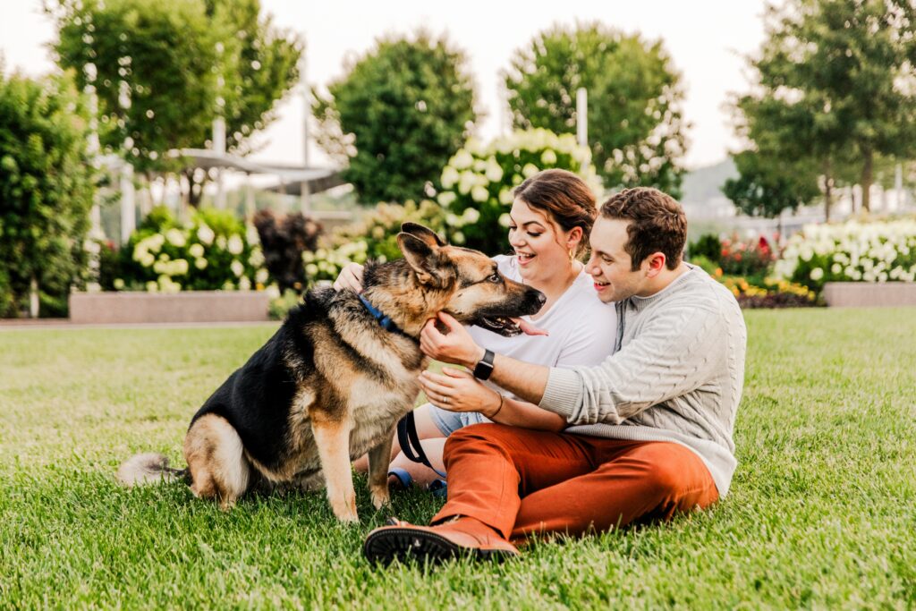 Laughing couple during their engagement session with thei dog at park in Cincinnati OH